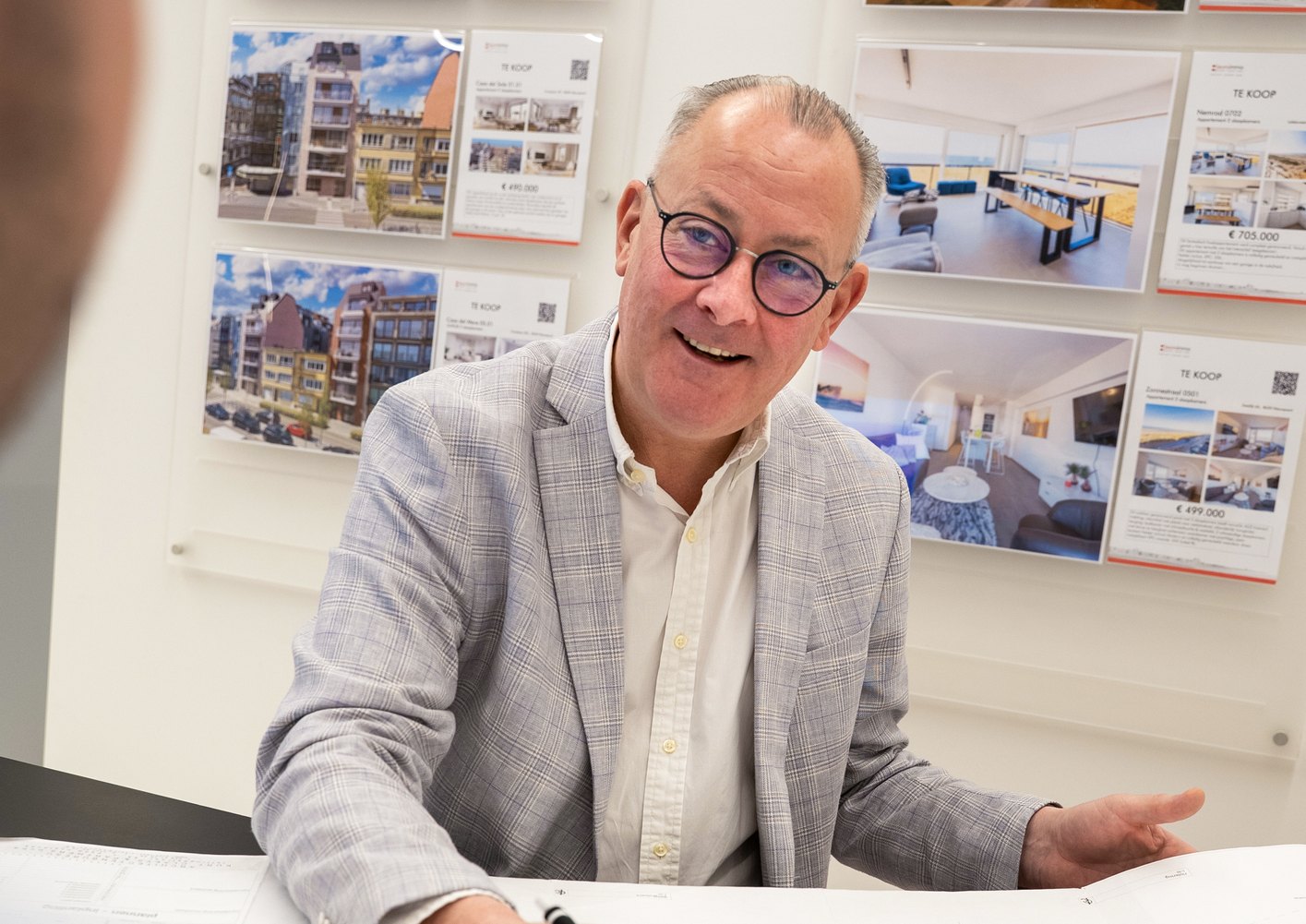 Collega van euro immo op kantoor voor een wand met panden