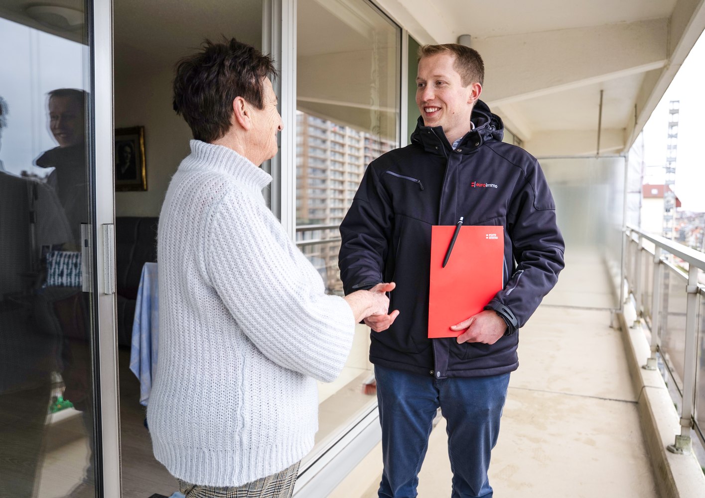 Adviseur verwelkomt een huurder op een appartementsterras